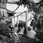 Longfellow and his wife relax on their porch at Edgecliff