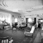 Note the floral wallpaper, carved ceiling, and spacious, light-filled living room